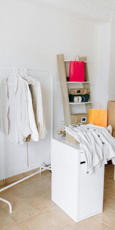 A modern interior with shopping bags, clothing rack, and minimalist design elements.