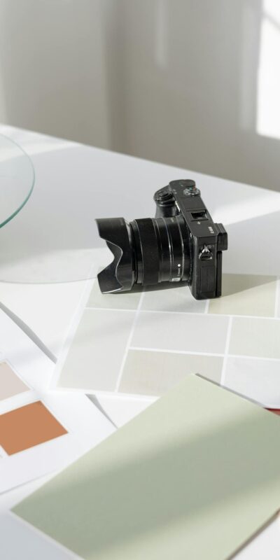 Digital camera resting on a desk with color swatches and design materials.