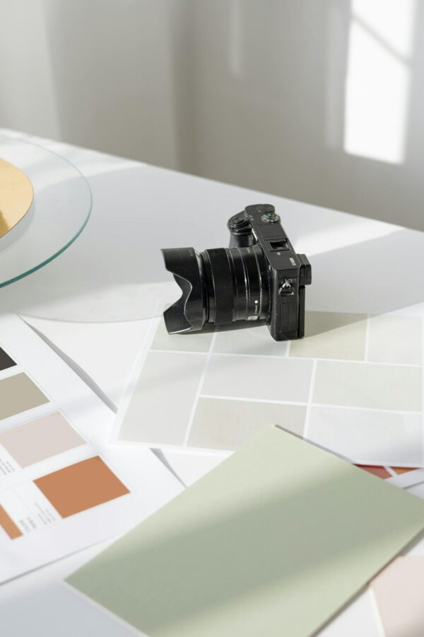 Digital camera resting on a desk with color swatches and design materials.